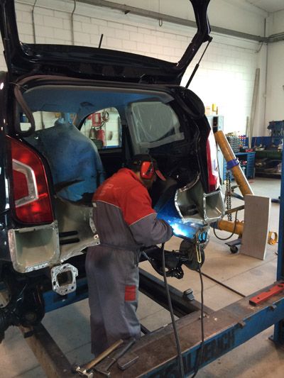 Saldatura sul retro di un'auto sollevata sul banco